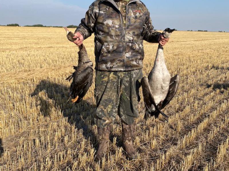 Byrd Smith holds a giant Canada goose & a specklebelly goose from a pea field shoot.